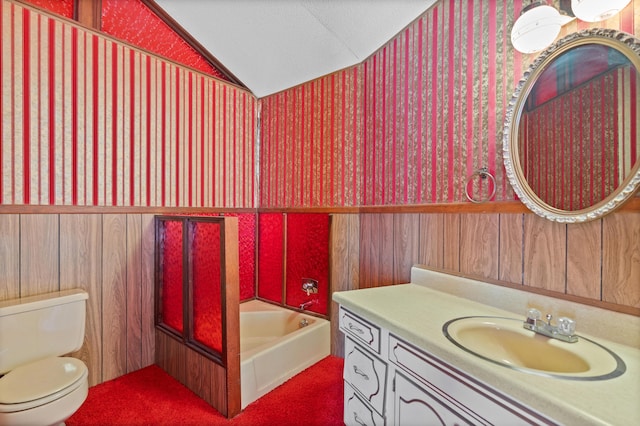 bathroom featuring lofted ceiling, toilet, wood walls, vanity, and a tub