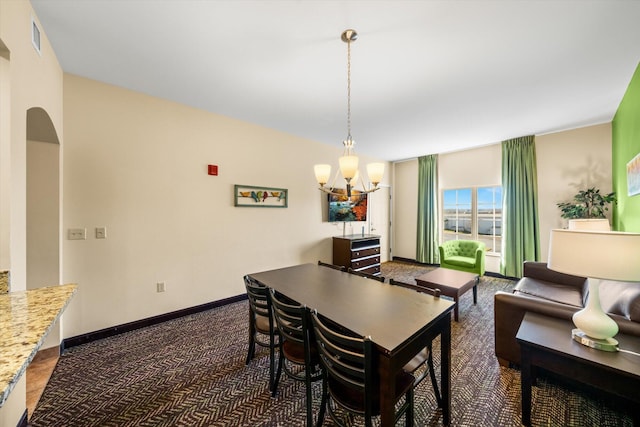 carpeted dining room featuring a chandelier