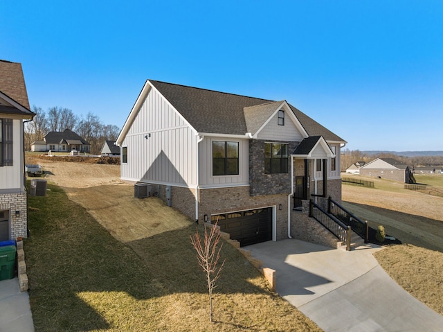 view of front of house featuring driveway, a garage, central air condition unit, board and batten siding, and brick siding