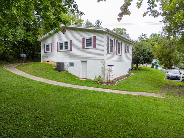 view of side of home featuring a yard and central AC unit