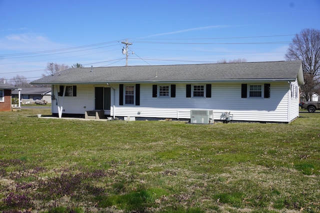 rear view of house with a yard and central AC unit