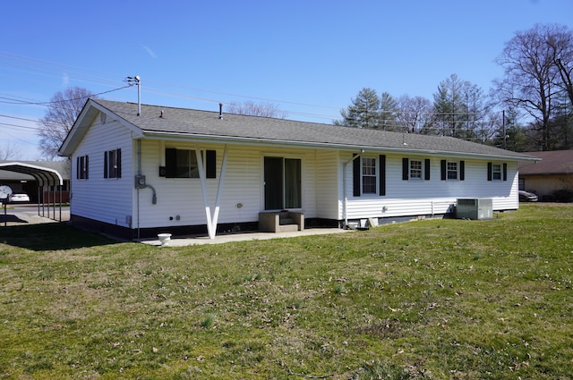 back of property featuring a detached carport, central AC, and a yard