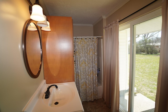 full bathroom featuring shower / bath combination with curtain, ornamental molding, a textured ceiling, and a sink