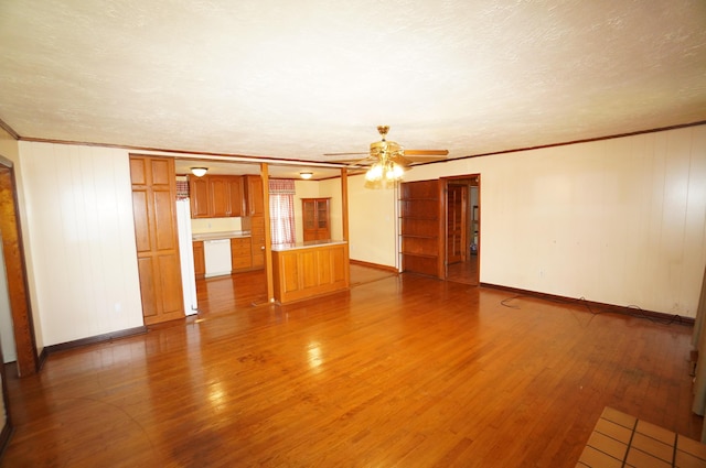 unfurnished living room with light wood finished floors, a textured ceiling, a ceiling fan, and ornamental molding