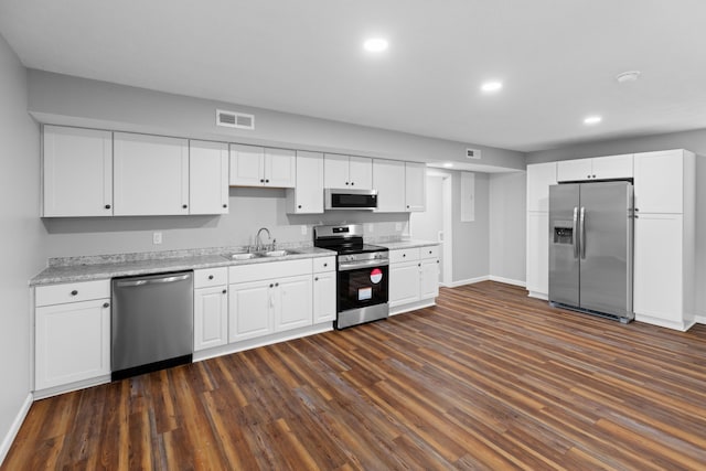 kitchen featuring dark wood-type flooring, a sink, visible vents, white cabinetry, and appliances with stainless steel finishes