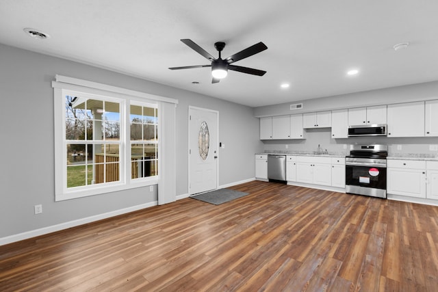 kitchen with dark wood-style flooring, visible vents, stainless steel appliances, and a sink