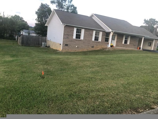 view of front of property with a front yard and central AC