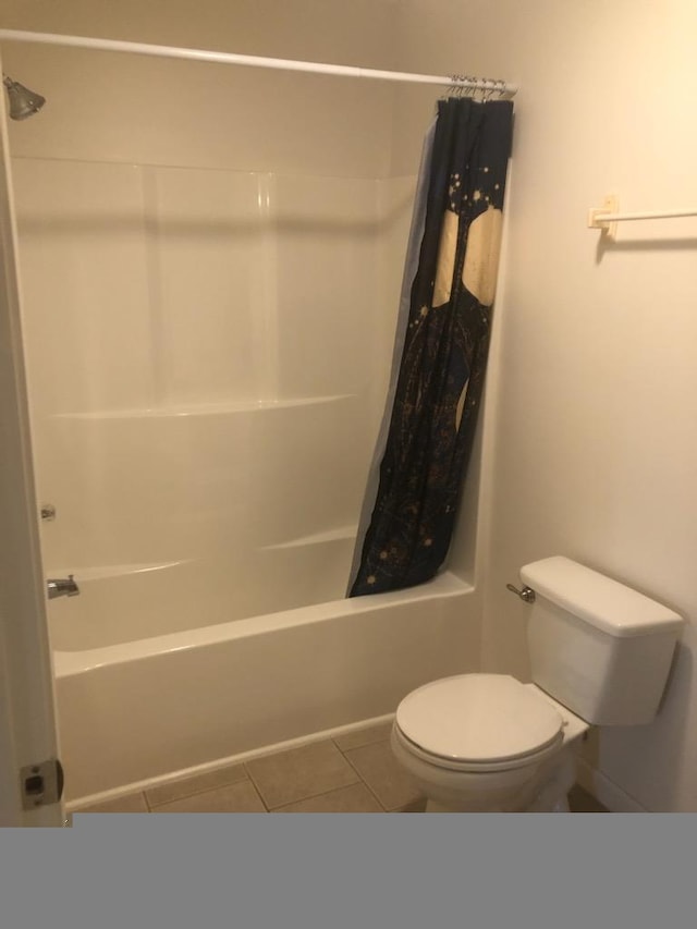 bathroom with tile patterned flooring, shower / tub combo, and toilet