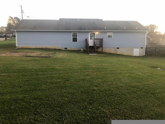 back of property featuring a lawn