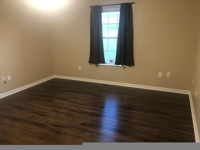 empty room with dark hardwood / wood-style flooring