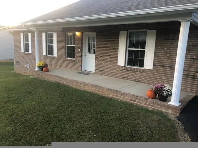 property entrance with a lawn