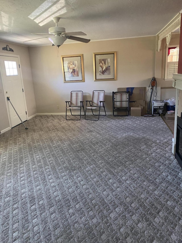 living area featuring a textured ceiling, carpet, and a healthy amount of sunlight