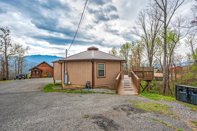 view of side of home featuring a deck with mountain view