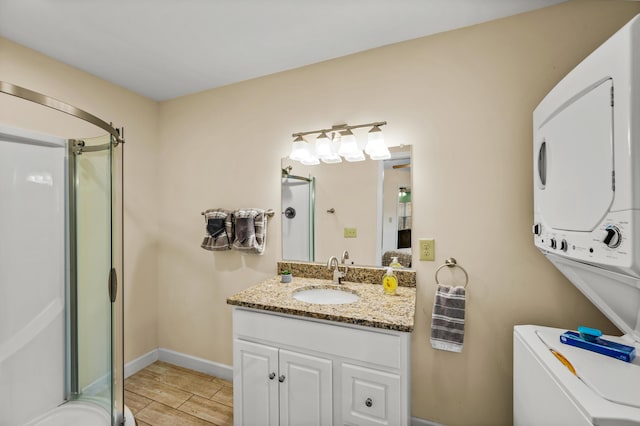 bathroom featuring stacked washer and dryer, vanity, and a shower with door