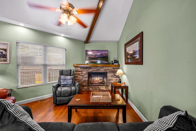 living room with vaulted ceiling with beams, ceiling fan, wood-type flooring, and a fireplace