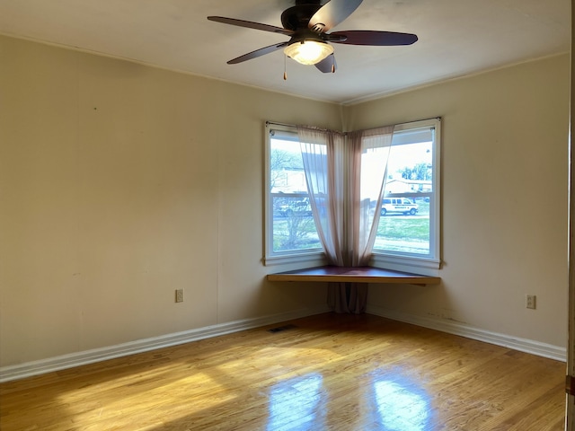 empty room with light wood-type flooring and ceiling fan