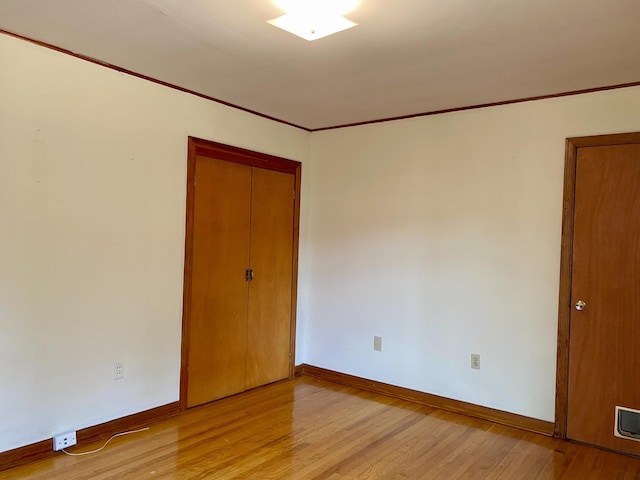 spare room with light hardwood / wood-style flooring and crown molding