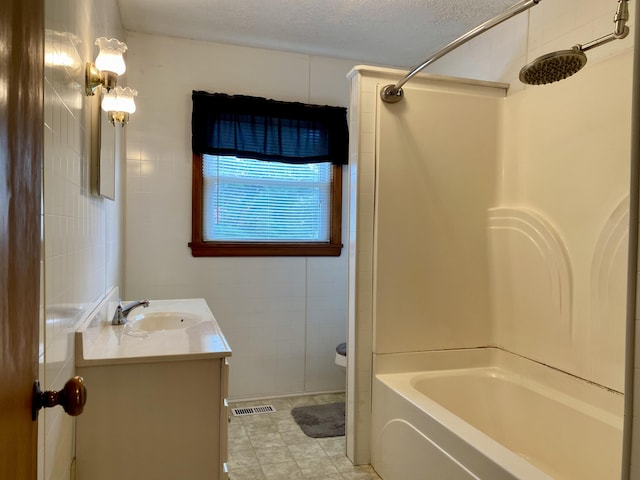 bathroom with shower / tub combination, vanity, and a textured ceiling