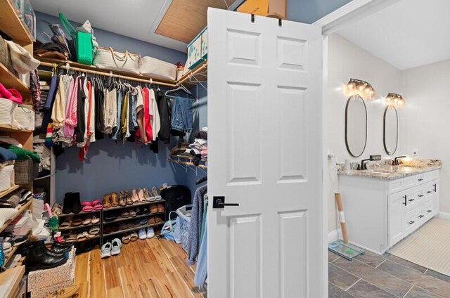 spacious closet with wood finished floors and a sink
