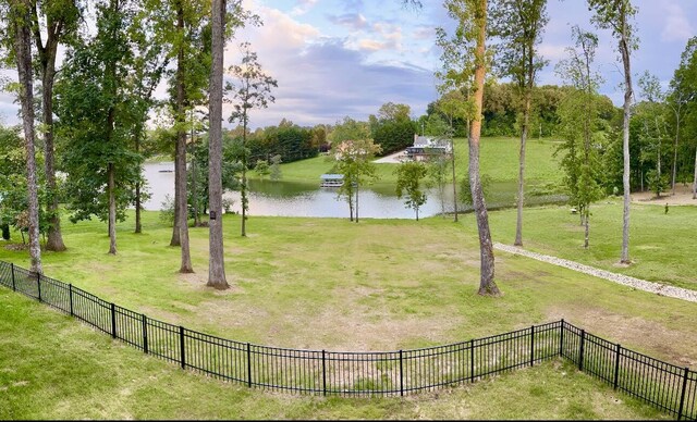 view of home's community featuring a water view, fence, and a yard
