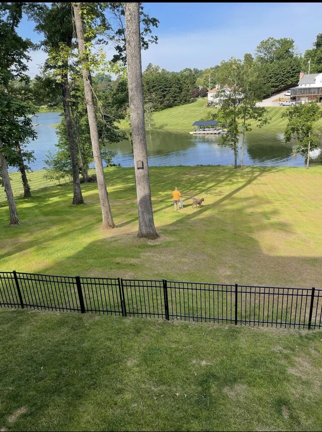 view of yard featuring a water view and fence