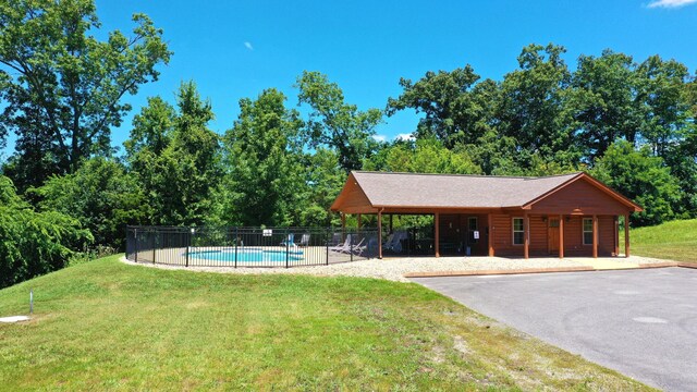 community pool featuring a lawn, fence, and a patio