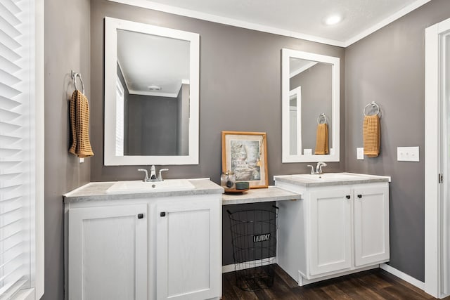 bathroom with two vanities, wood finished floors, baseboards, and a sink