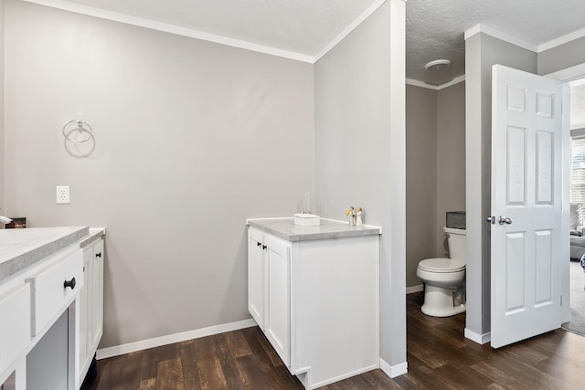 bathroom featuring vanity, crown molding, wood finished floors, and baseboards