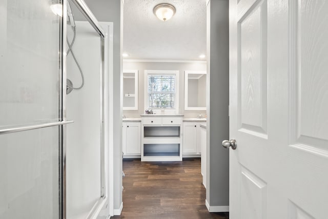 bathroom with crown molding, a stall shower, wood finished floors, a textured ceiling, and vanity