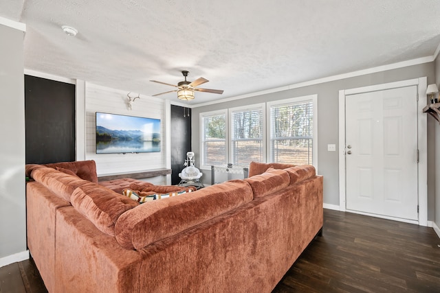 living room with dark wood-style floors, baseboards, ceiling fan, a textured ceiling, and crown molding