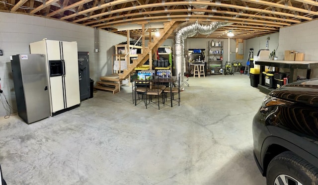 basement with stainless steel fridge and white fridge with ice dispenser