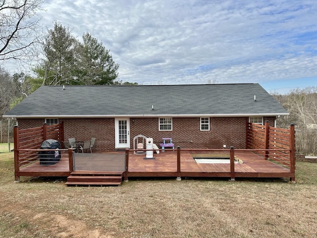 rear view of property with a yard and a wooden deck