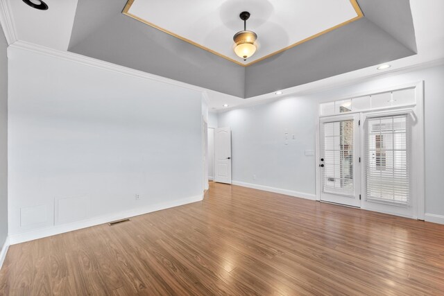 spare room featuring crown molding, a tray ceiling, and hardwood / wood-style floors