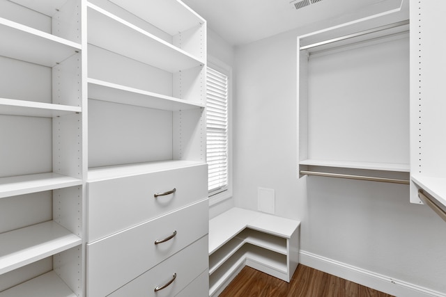 spacious closet with dark hardwood / wood-style flooring