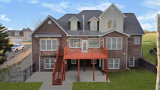 rear view of property featuring a deck, a lawn, and a patio