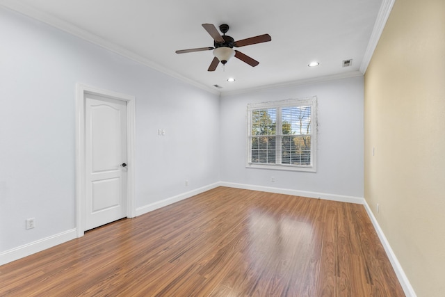 empty room featuring ceiling fan, crown molding, and hardwood / wood-style flooring