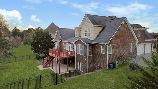 rear view of house with a garage, a wooden deck, a yard, and a patio