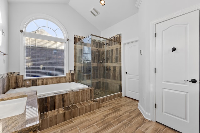 bathroom with vaulted ceiling, shower with separate bathtub, and vanity