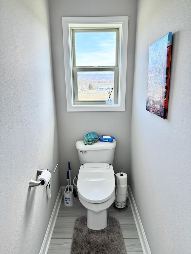 bathroom with toilet and baseboards