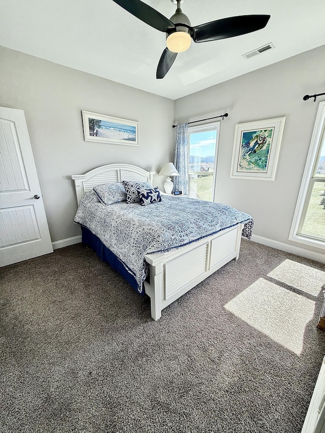 bedroom with baseboards, visible vents, dark colored carpet, and a ceiling fan