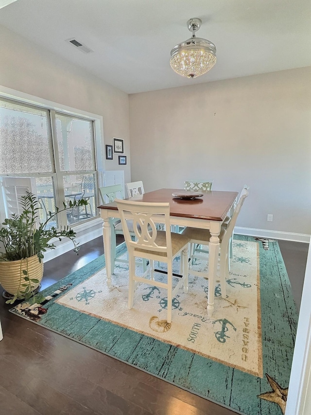 dining space with baseboards, visible vents, and wood finished floors