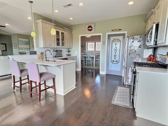 kitchen with light countertops, appliances with stainless steel finishes, decorative backsplash, and visible vents
