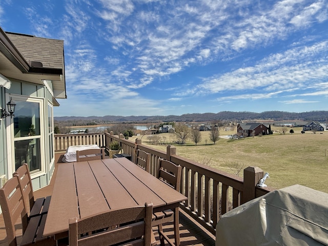 deck with outdoor dining area and a mountain view