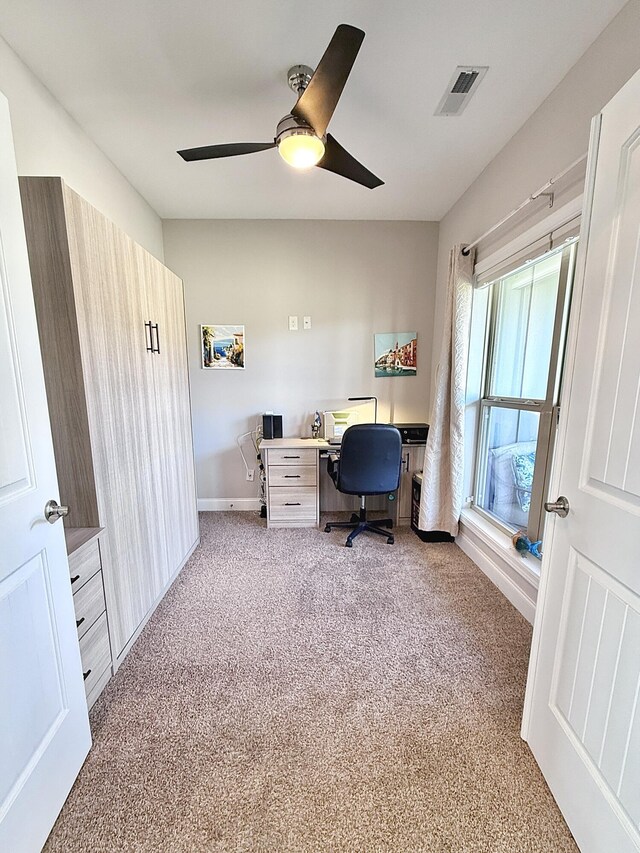 office area with baseboards, ceiling fan, visible vents, and carpet floors