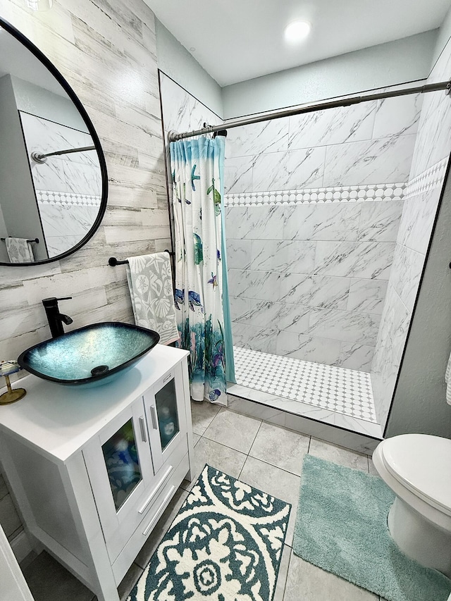 bathroom featuring vanity, toilet, a shower stall, and wood walls