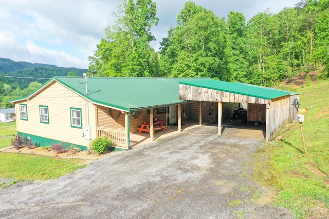 3500 Poor Valley Rd, Rutledge, TN 37861 - view of front facade featuring driveway, a carport, metal roof, and a forest view