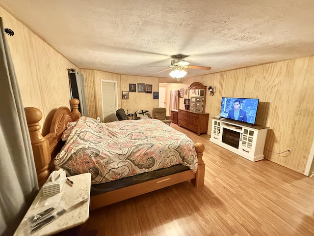 3500 Poor Valley Rd, Rutledge, TN 37861 - bedroom with wood finished floors, wooden walls, a textured ceiling, and ceiling fan