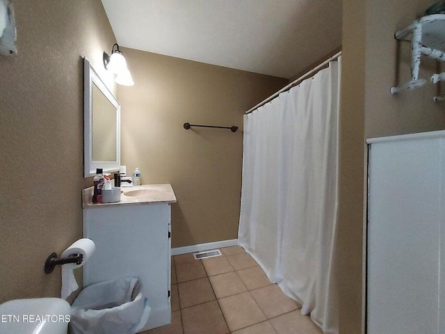 bathroom with toilet, vanity, and tile patterned floors