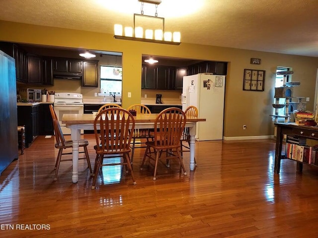 dining room with hardwood / wood-style floors, a textured ceiling, and sink