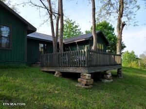 rear view of property with a lawn and a wooden deck